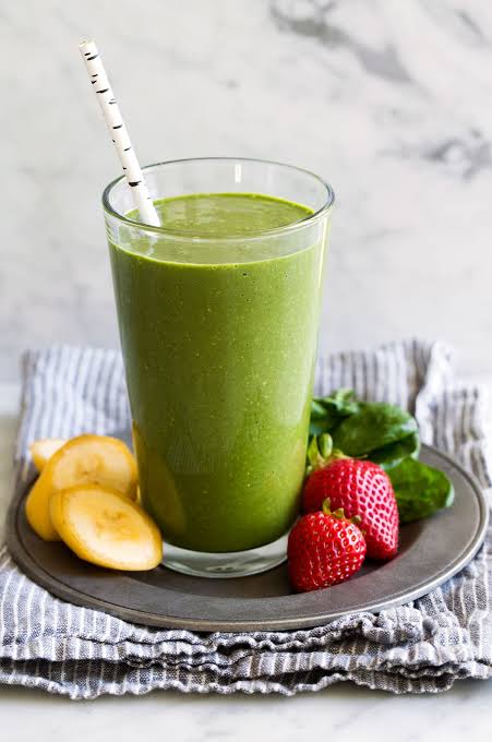 Green smoothie in a glass with fruit